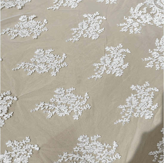 Repeating floral embroidery with open tulle spaces on bridal lace fabric
